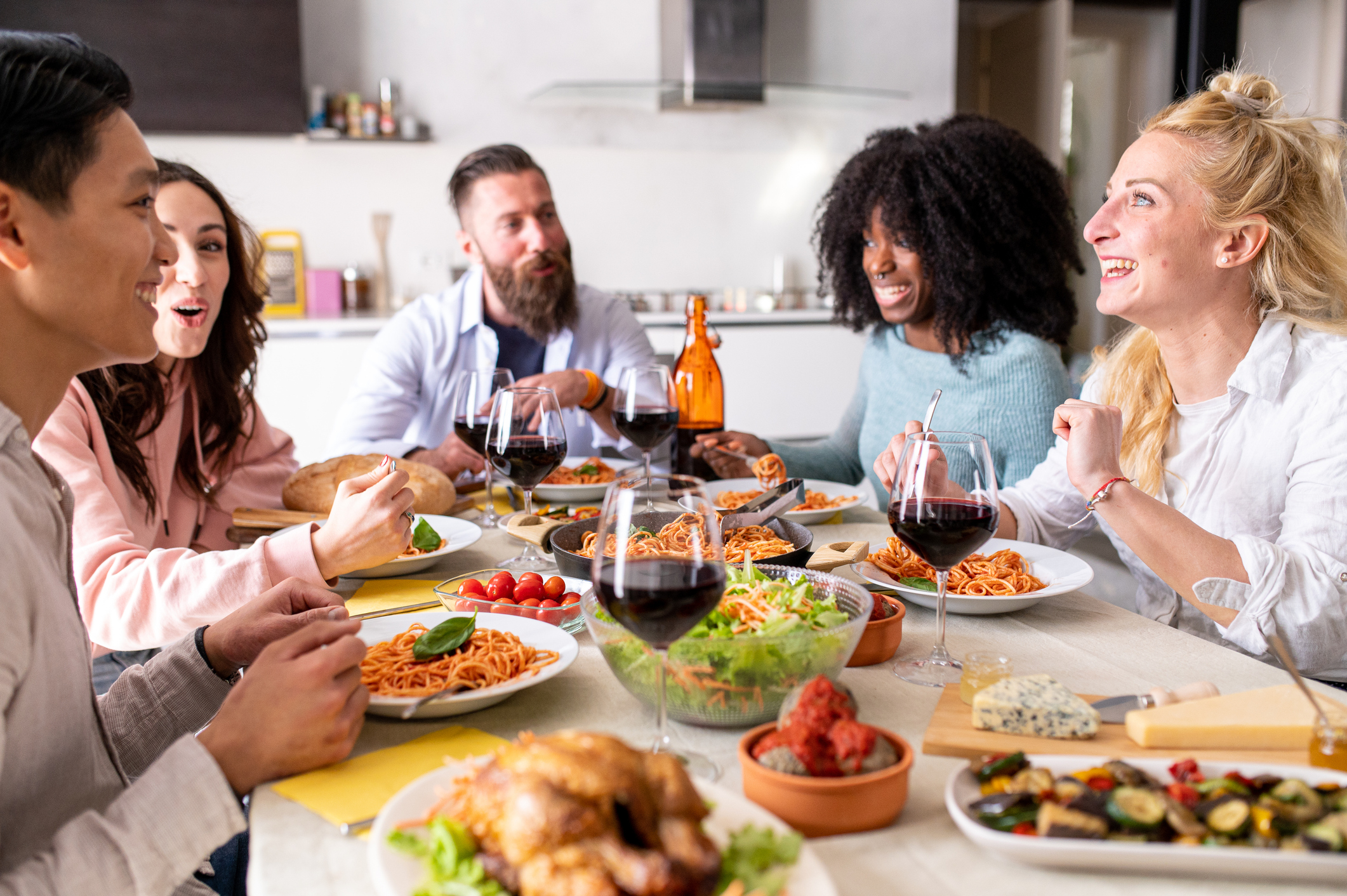 Menschen essen gemeinsam an einem großen Tisch in geselliger Runde.