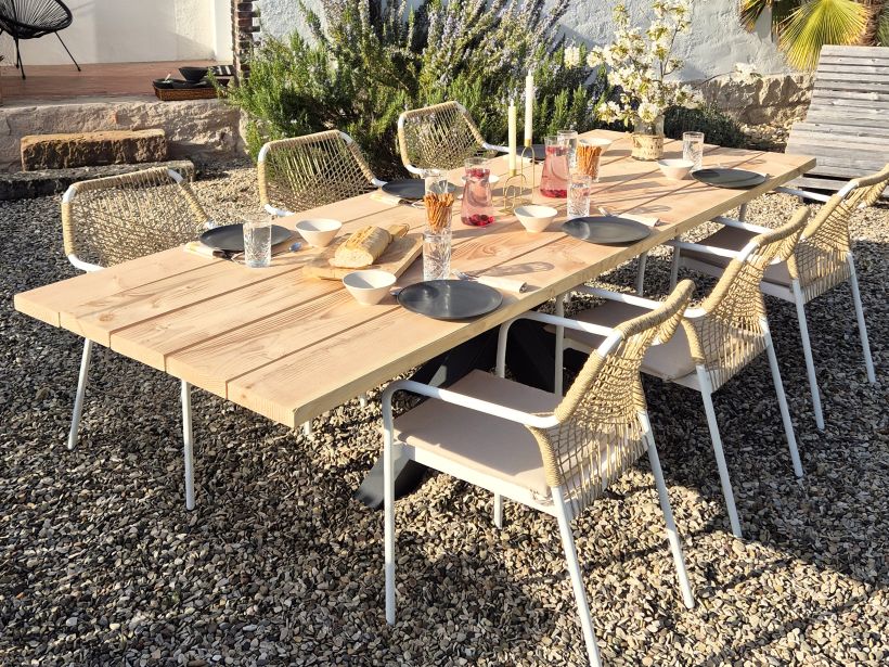 Großer Douglasie Gartentisch mit naturbelassener Platte und Metallgestell, umgeben von Outdoor-Stühlen