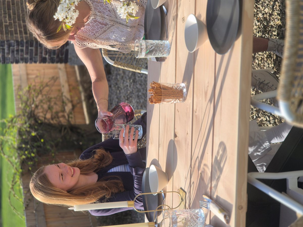 Gartenmöbel aus Douglasie mit zwei Personen an einem Holz-Gartentisch